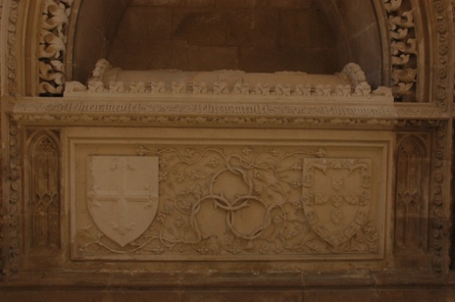 La tombe du saint Infant dans la chapelle royale du monastère de Batalha, chargée de sa devise de l’aubépine, du mot LE BIEN ME PLET, des armes de l’ordre d’Avis et de ses propres armes.