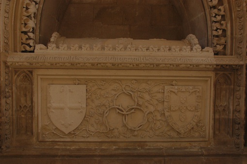 La tombe du saint Infant dans la chapelle royale du monast&egrave;re de Batalha, charg&eacute;e de sa devise de l&rsquo;aub&eacute;pine, du mot LE BIEN ME PLET, des armes de l&rsquo;ordre d&rsquo;Avis et de ses propres armes.